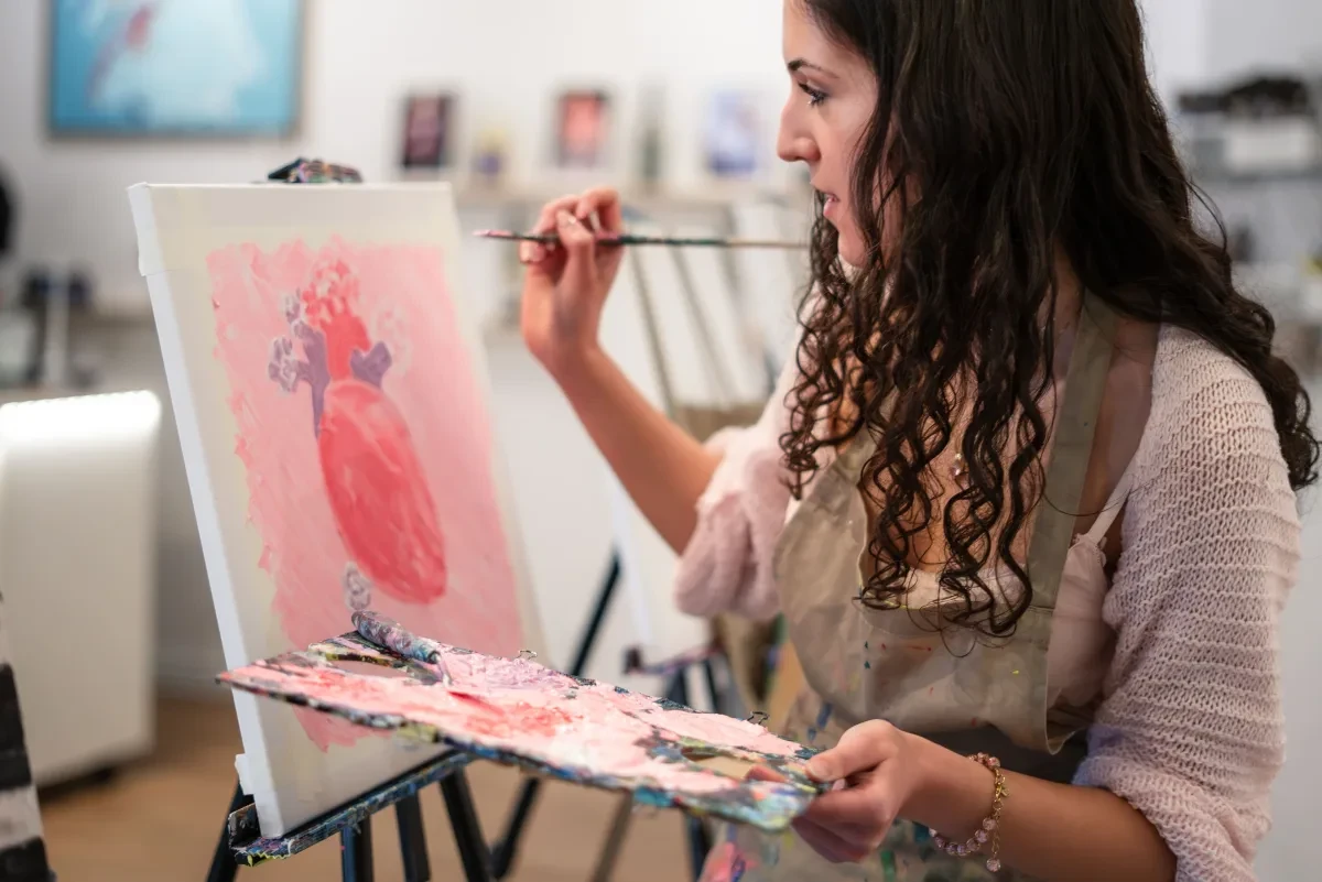 Eine Frau malt in einem hellen Atelier